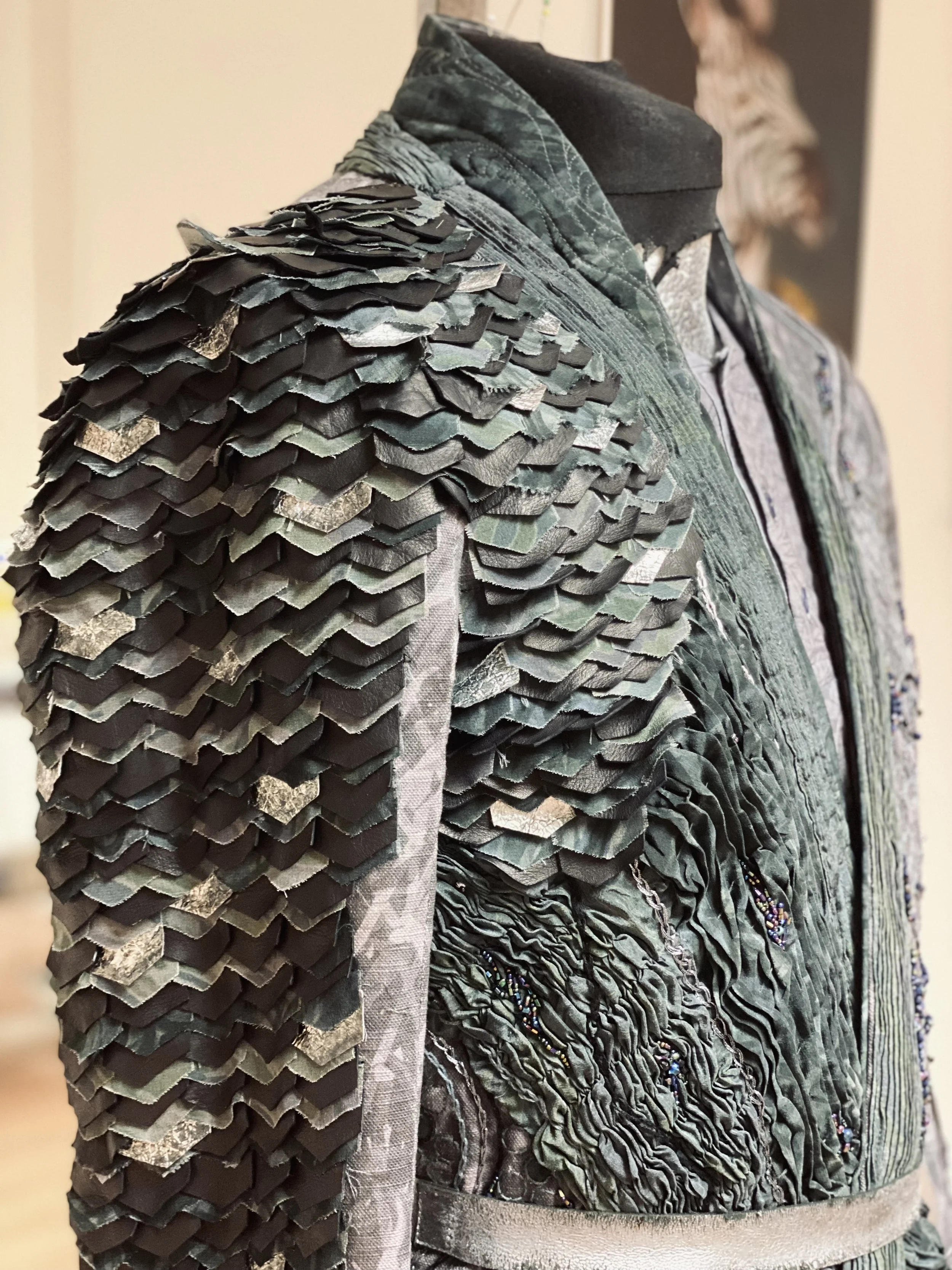Close-up of a designer jacket with layered, ruffled fabric and intricate detailing.