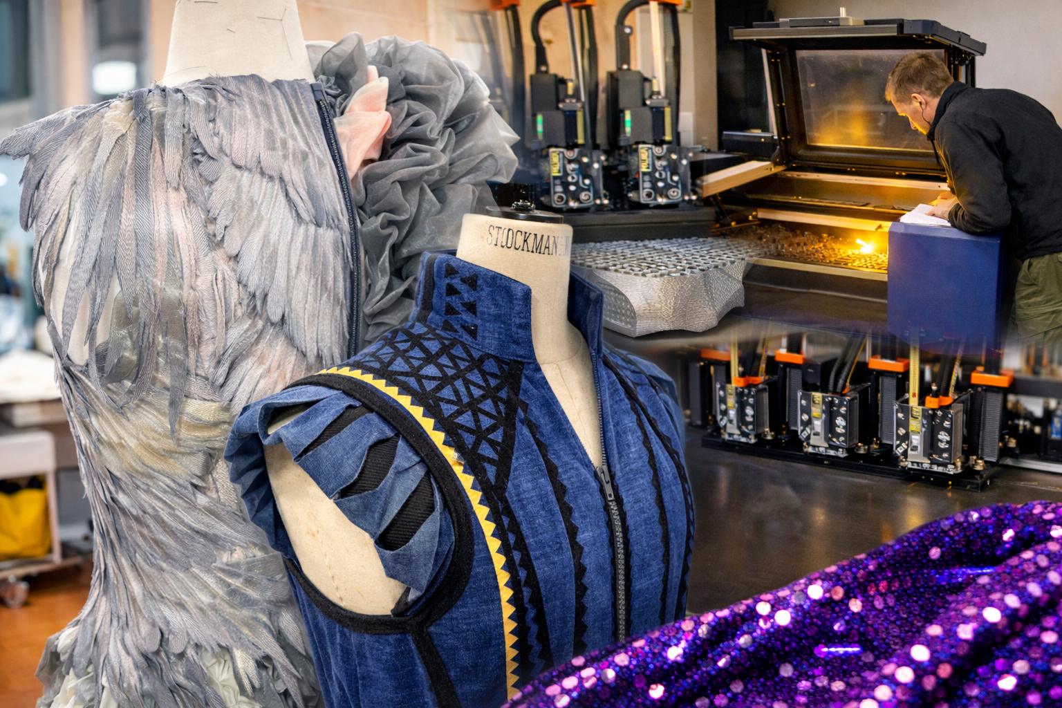 Man working in a 3D printer workshop with mannequins displaying creative clothing designs.