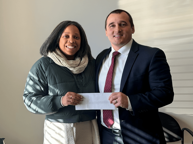Attorney Jerry Kramer with a client holding a settlement check