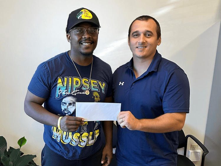 Attorney Jerry Kramer with a client holding a settlement check