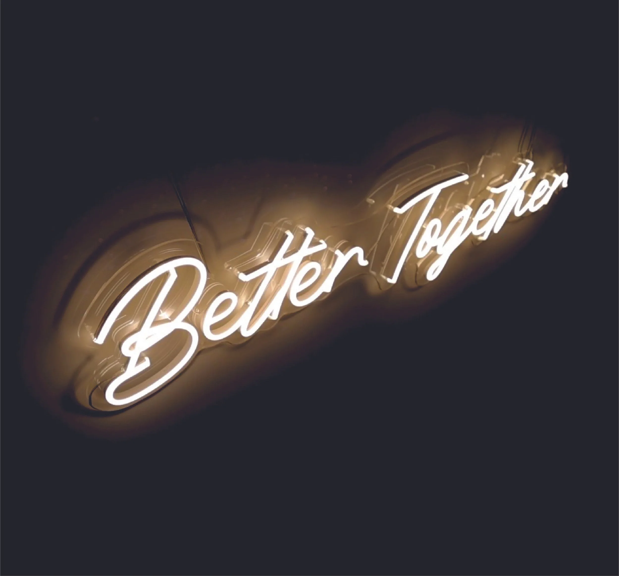 Neon sign that reads 'Better Together' in cursive on a dark background.
