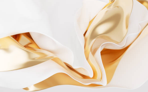 Close-up of crumpled white and gold satin fabric.