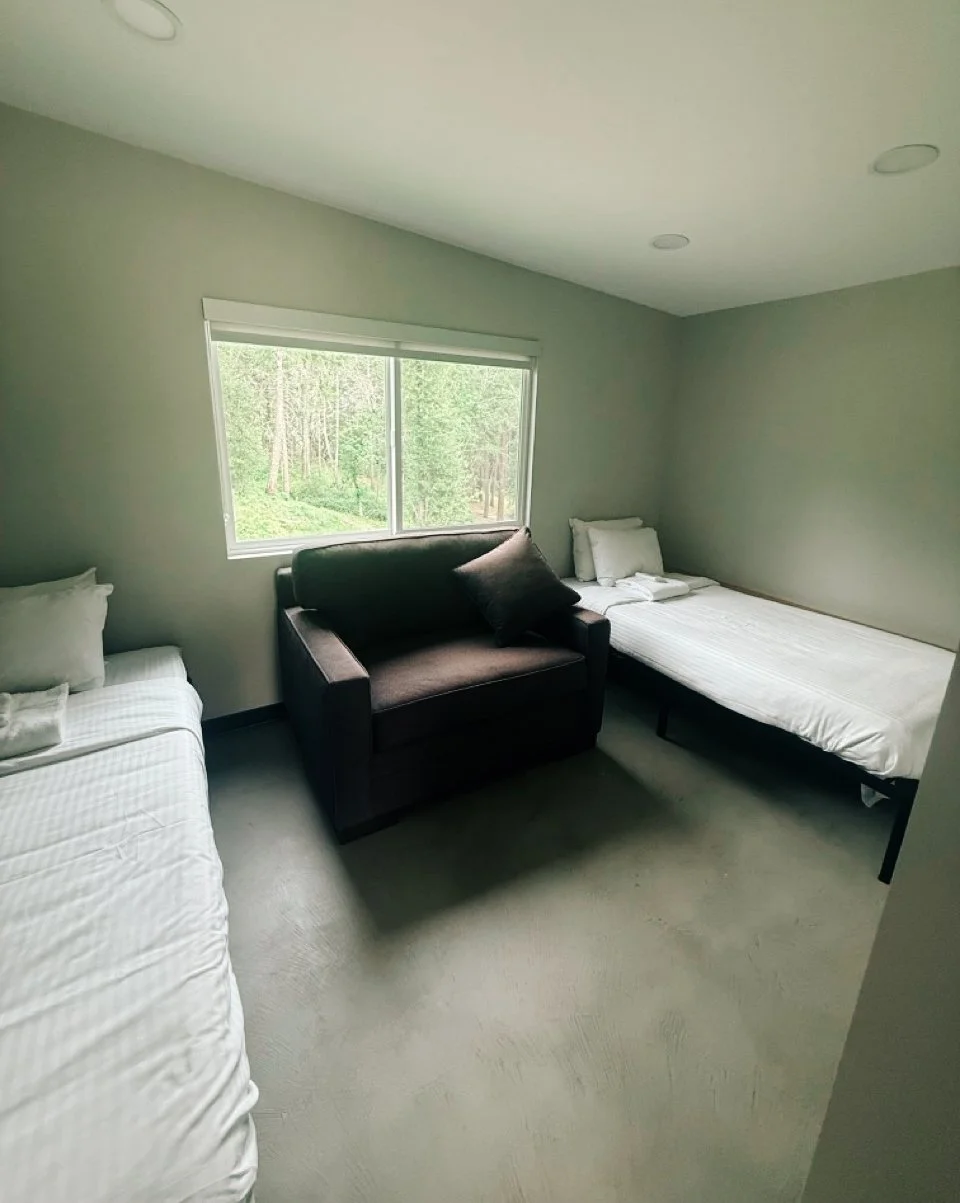 The bedroom in a Lakeside Cabin at Camp Coffee Shop features two twin beds.