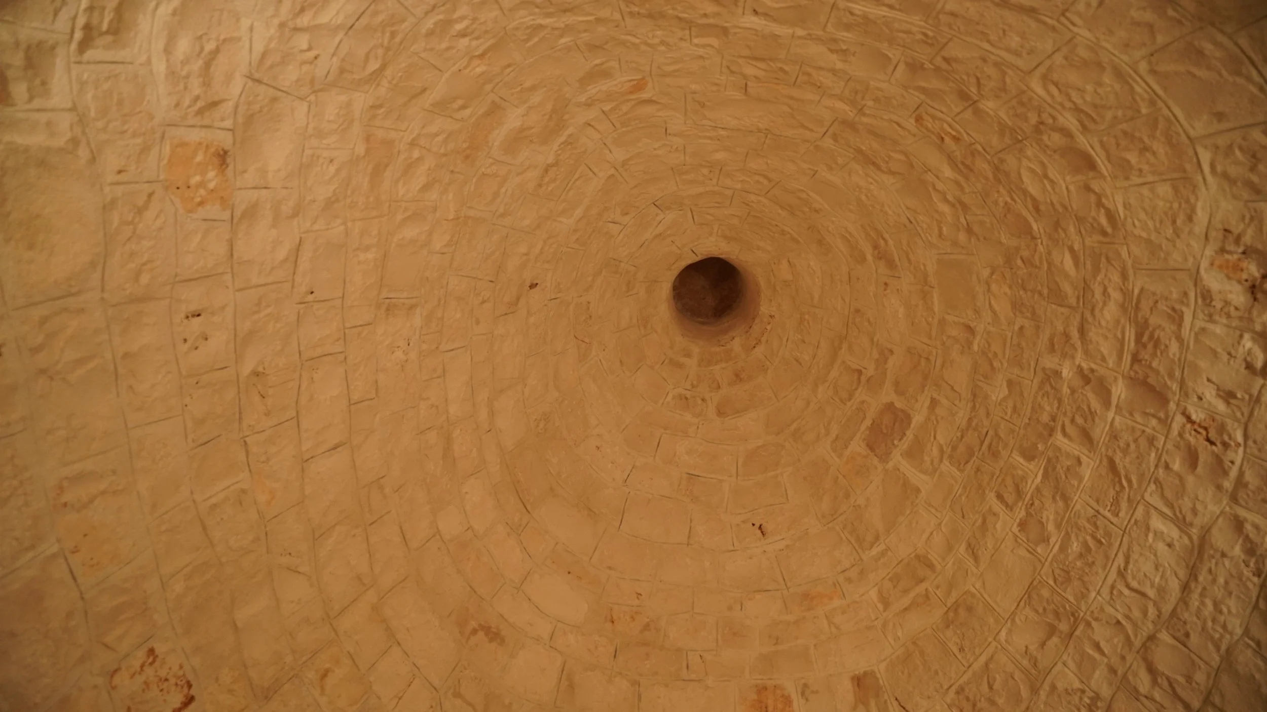 Visione dall'alto di un pozzo cilindrico di pietra con pareti curve