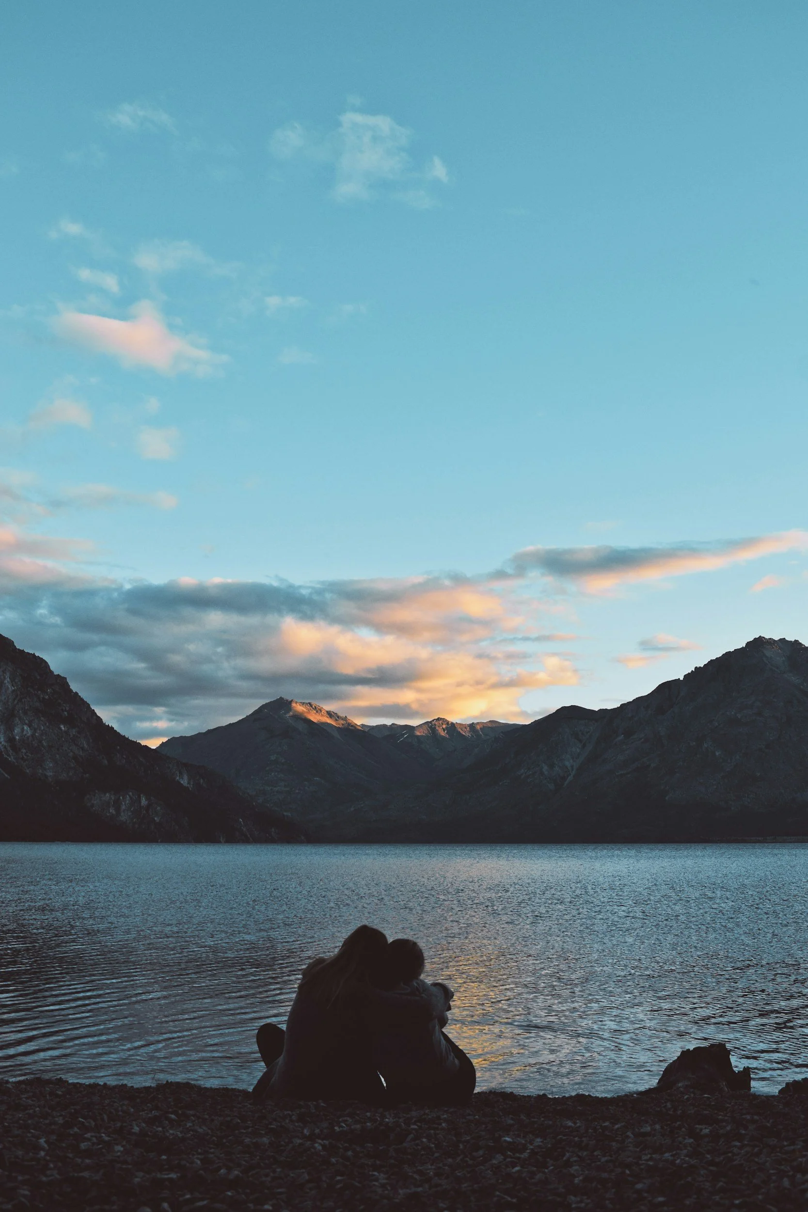 Couple sitting by the ocean, representing strong boundaries and a healthy relationship.