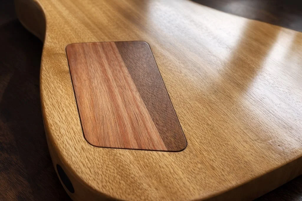 Pleased with how the acacia control cover contrasts against the limba body here. A few coats of Tru-Oil bring out the depth and grain. 

The positioning is deliberately slightly offset against the body grain but next time I might push this further to