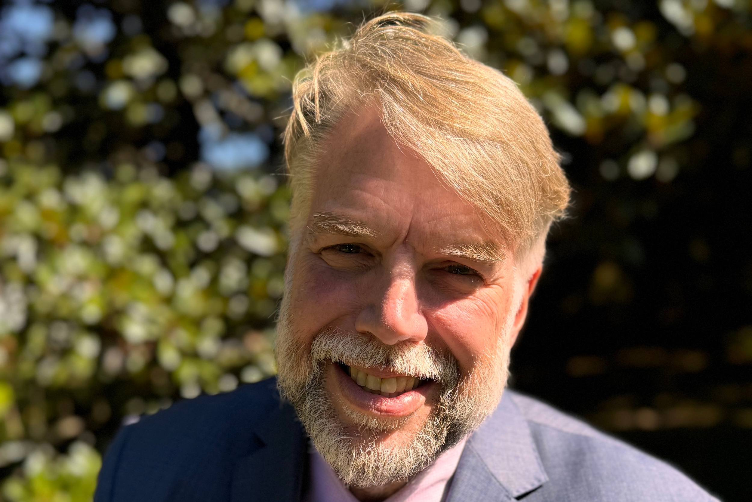A smiling older man with a beard