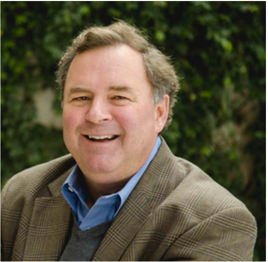 Smiling man outdoors with greenery