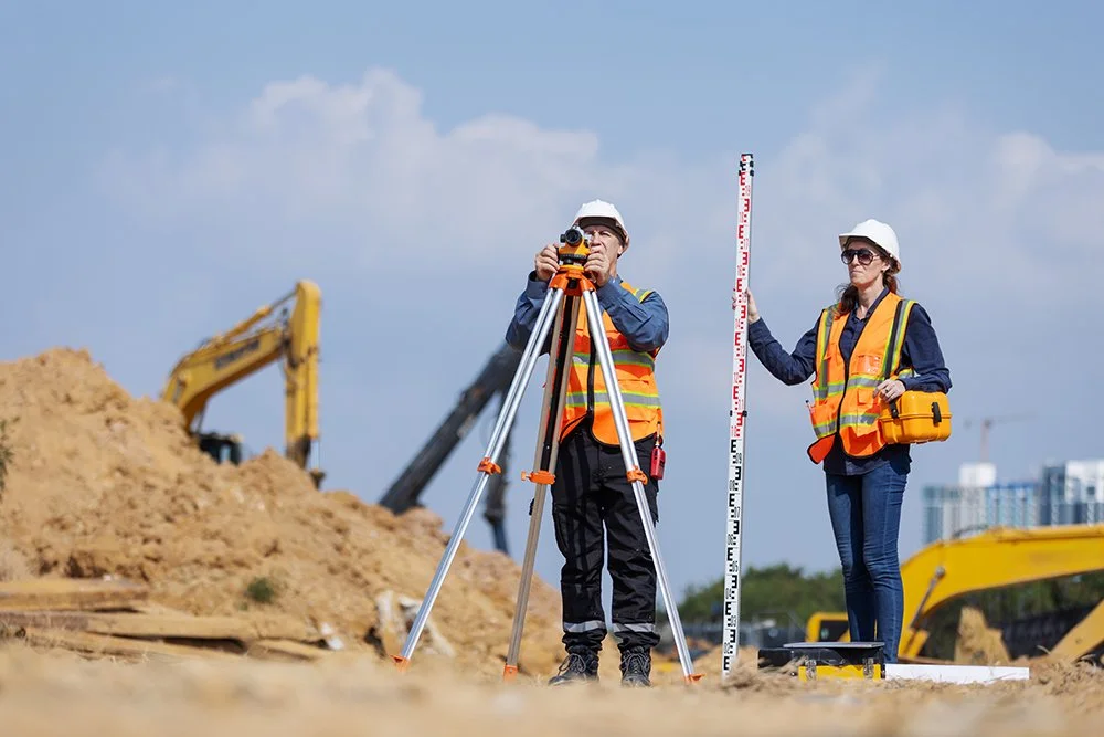 Male and female on construction site taking a survey of the land.