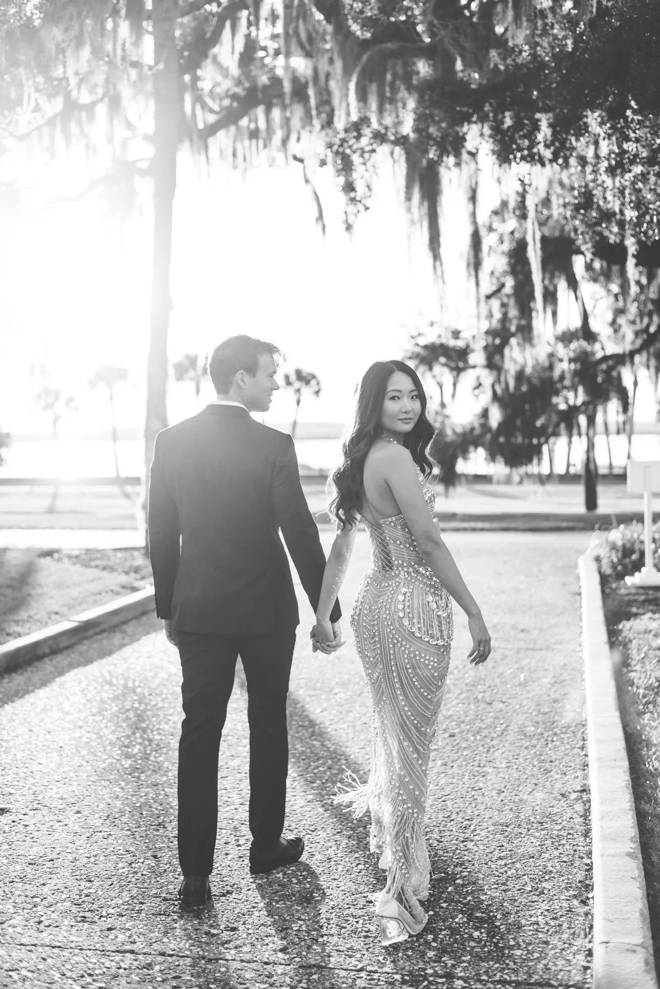 Elegant photo of a bride and groom walking on Jekyll Island before their rehearsal dinner.