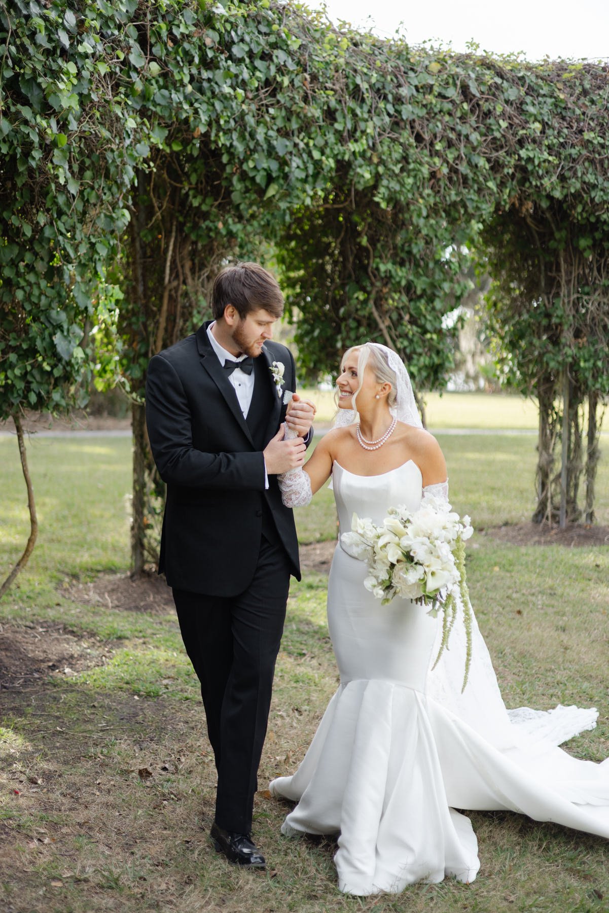 Bride and groom walking together through the garden