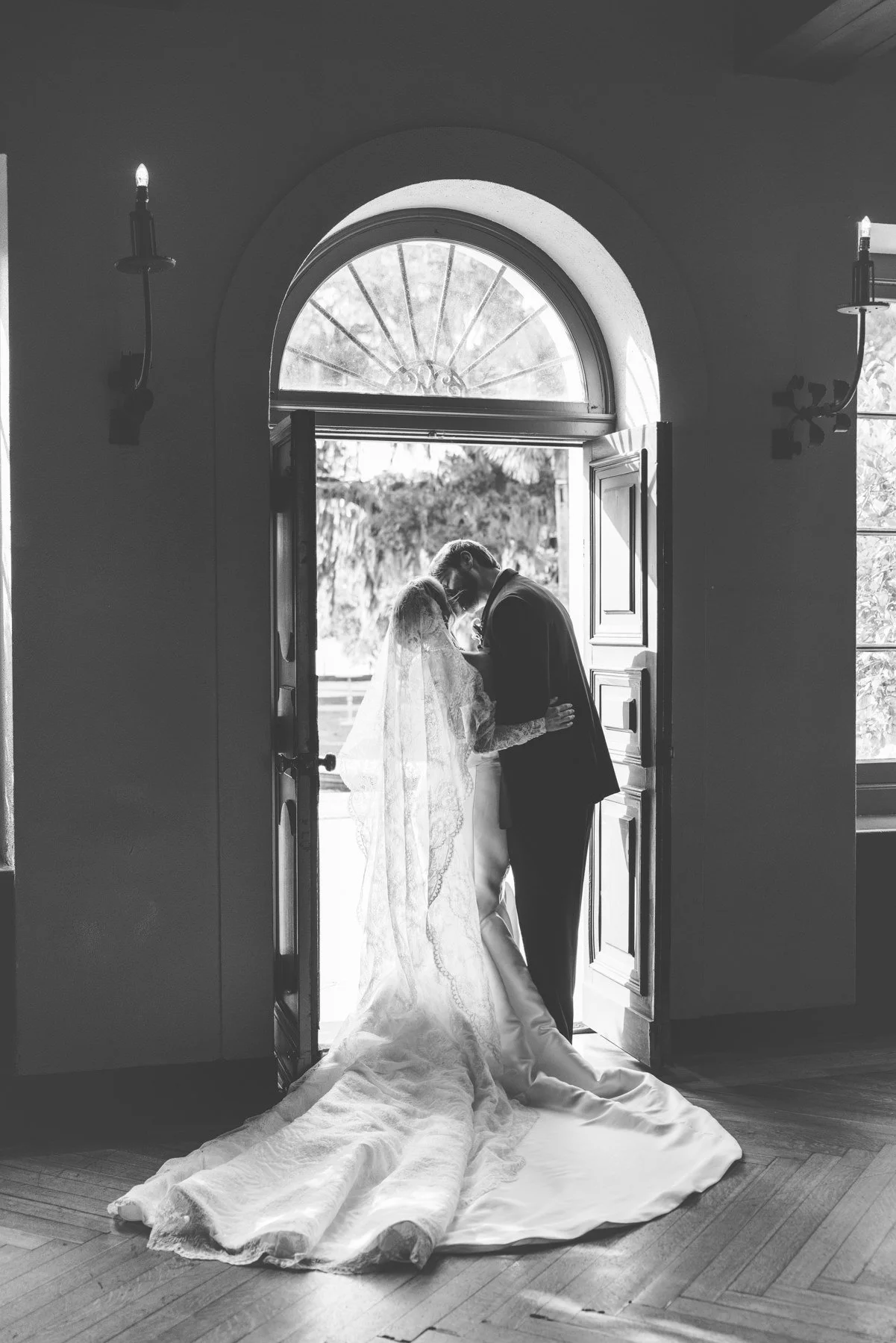 Black and white silhouette of bride and groom kissing