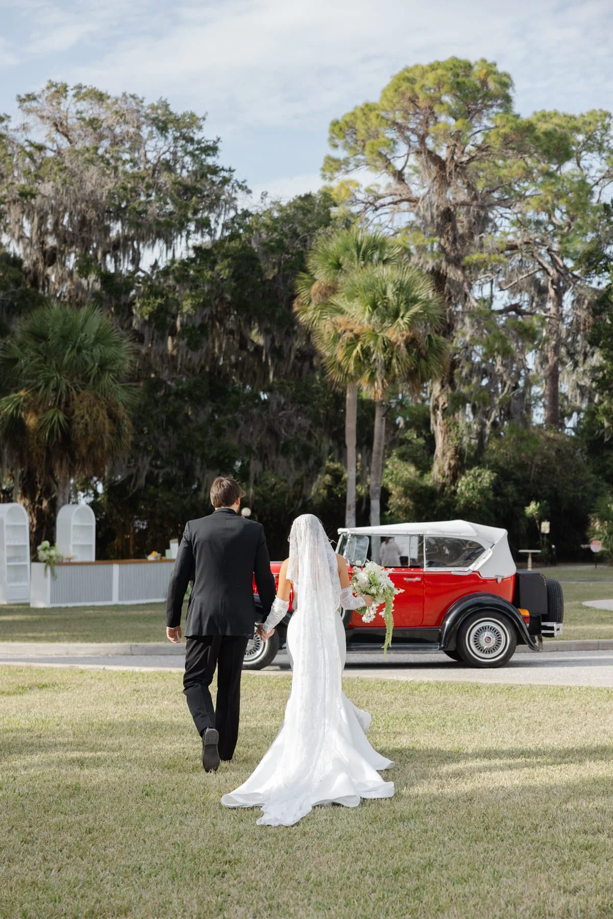 Bride and groom walking toward a classic car in the Golden Isles