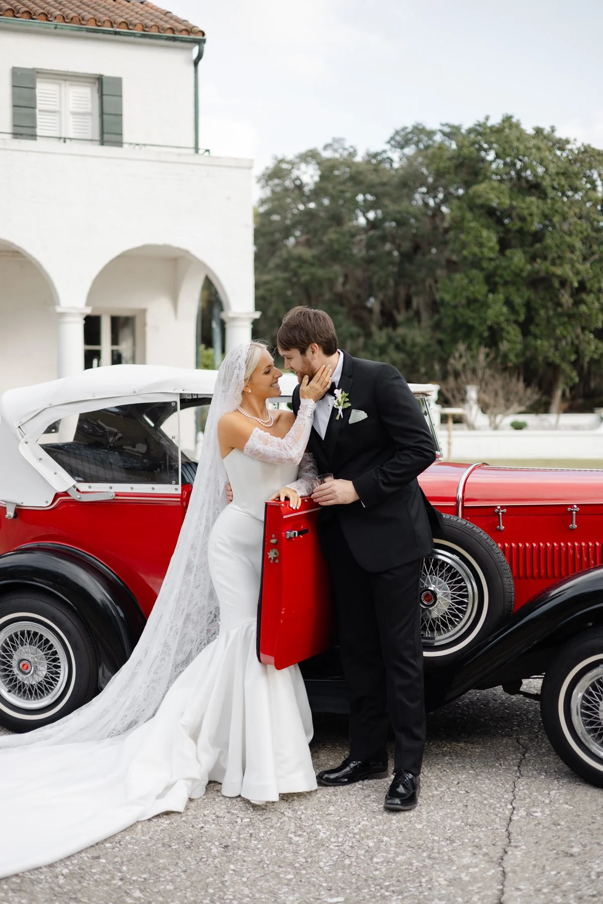 Bride and groom leaning on a classic car in the Golden Isles