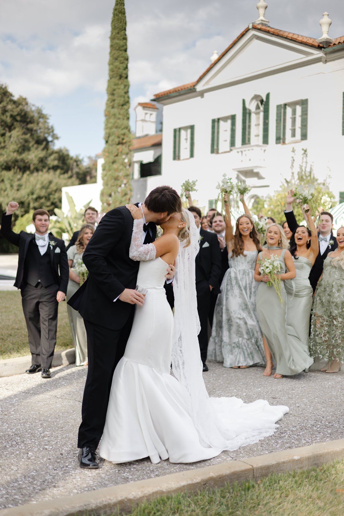 Bride and groom kissing with wedding party at Jekyll Island
