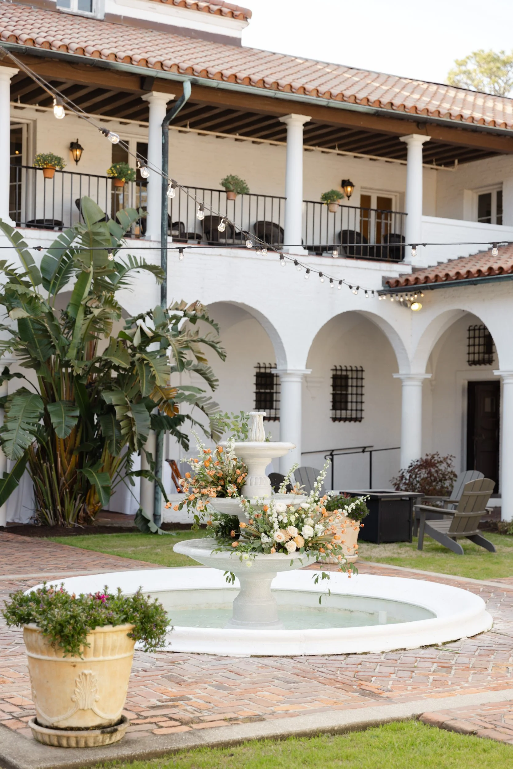 Wedding reception decor in the courtyard of Crane Cottage featuring a flower filled fountain on Jekyll Island.