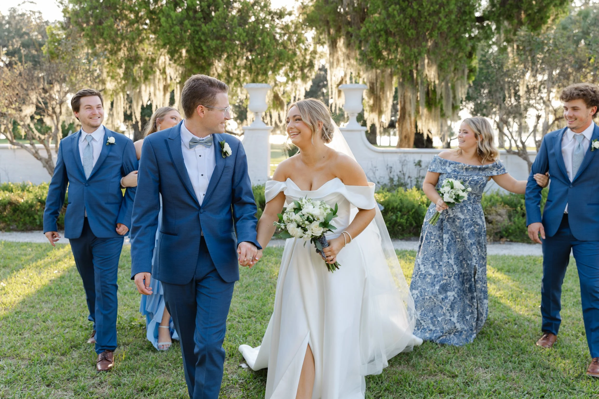 Candid photo of a bride and groom walking together in the Crane Cottage Sunken Garden after their ceremony on Jekyll Island.