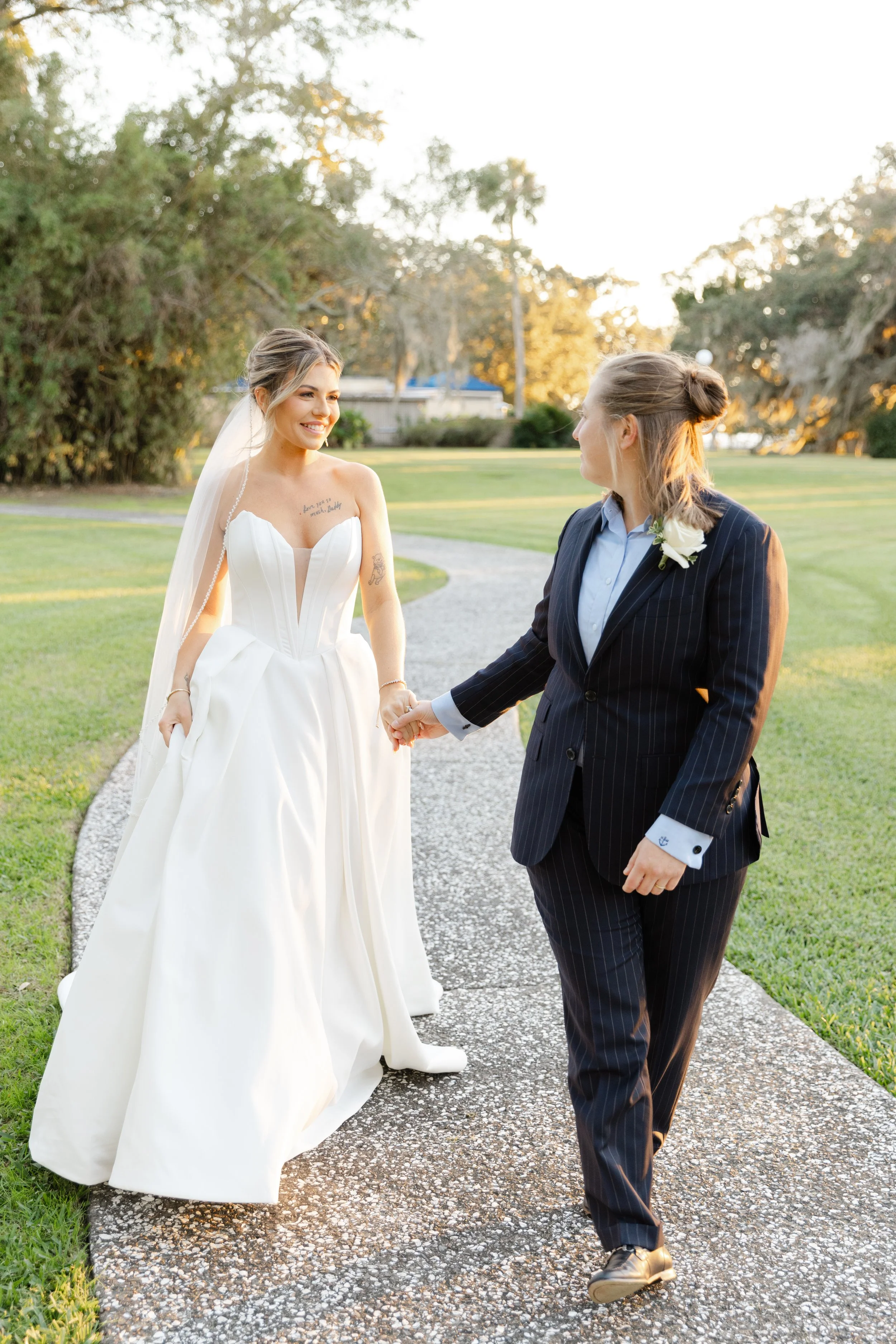 LGBTQ wedding photo of two brides walking in front of the Jekyll Island Club Hotel after their ceremony.