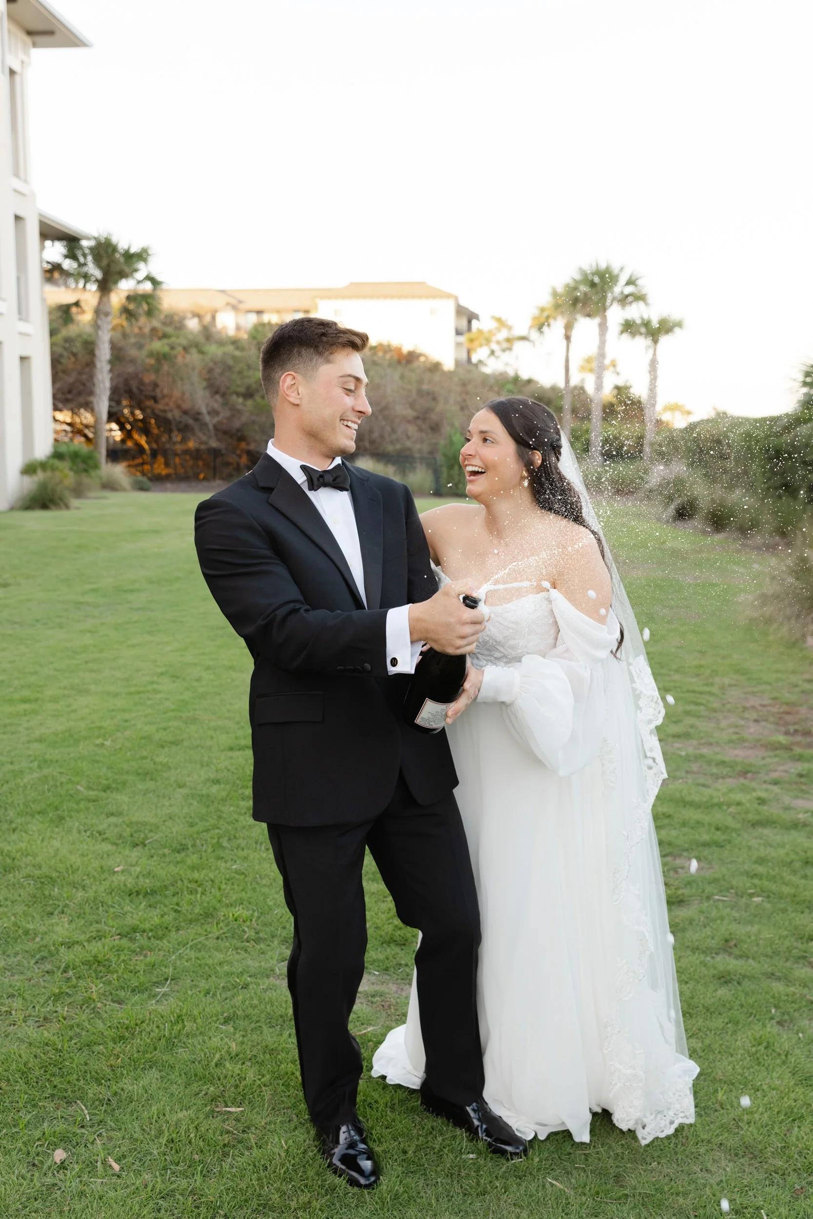 Bride and groom popping champagne at the Jekyll Island Beach Club after their wedding ceremony in Georgia.