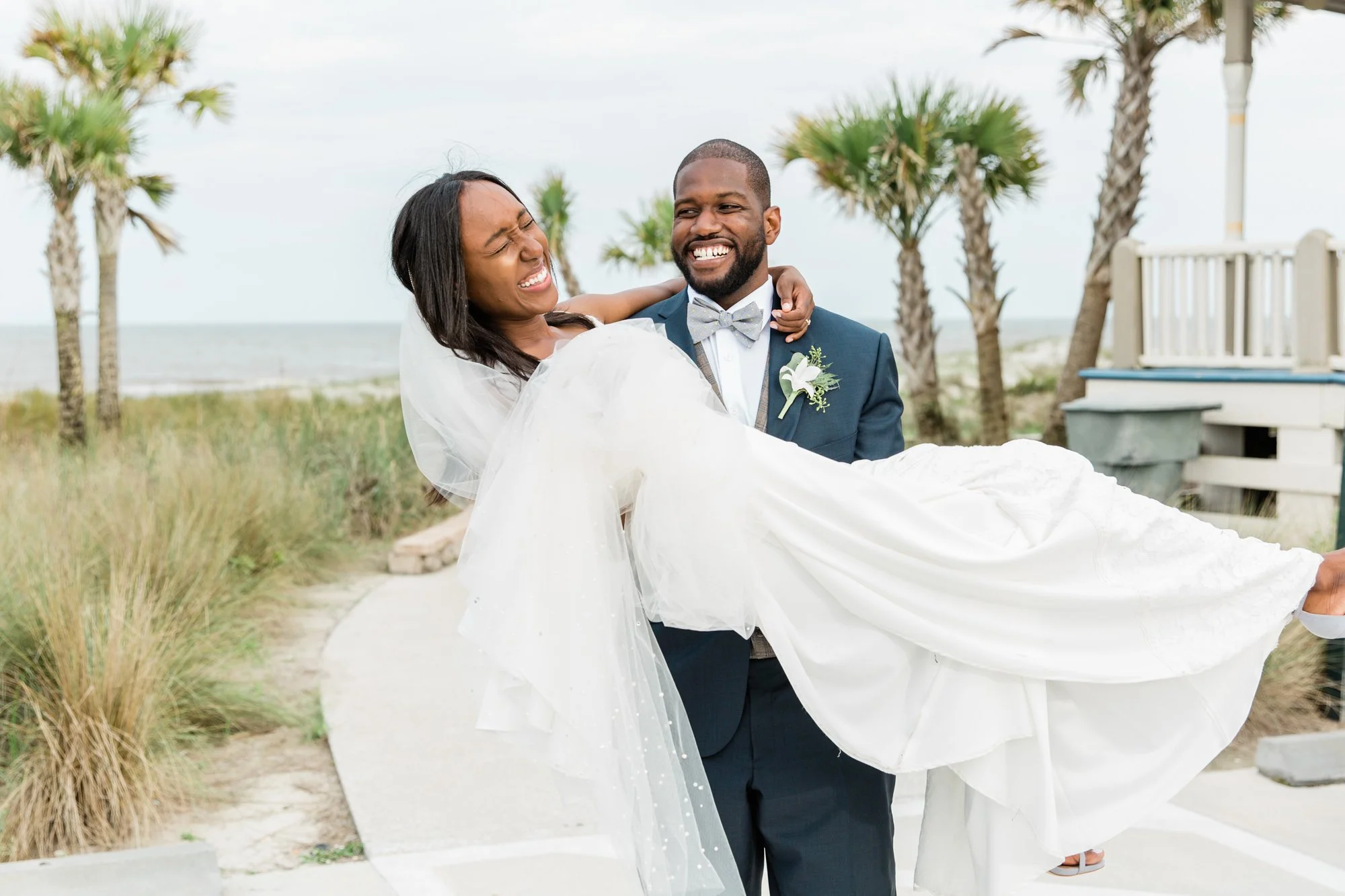 Fun candid photo of a bride and groom on the beach at Jekyll Island after their wedding ceremony.