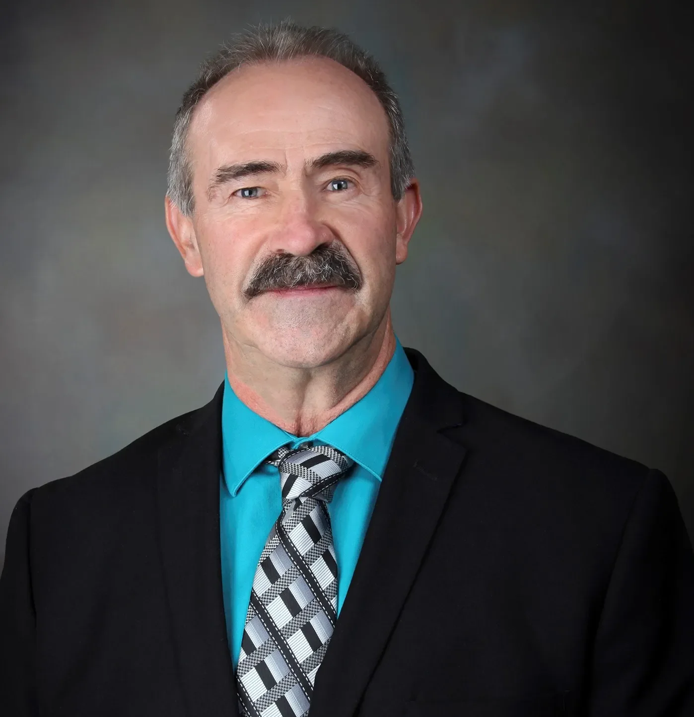 White Man with a moustache in a suit in a black background