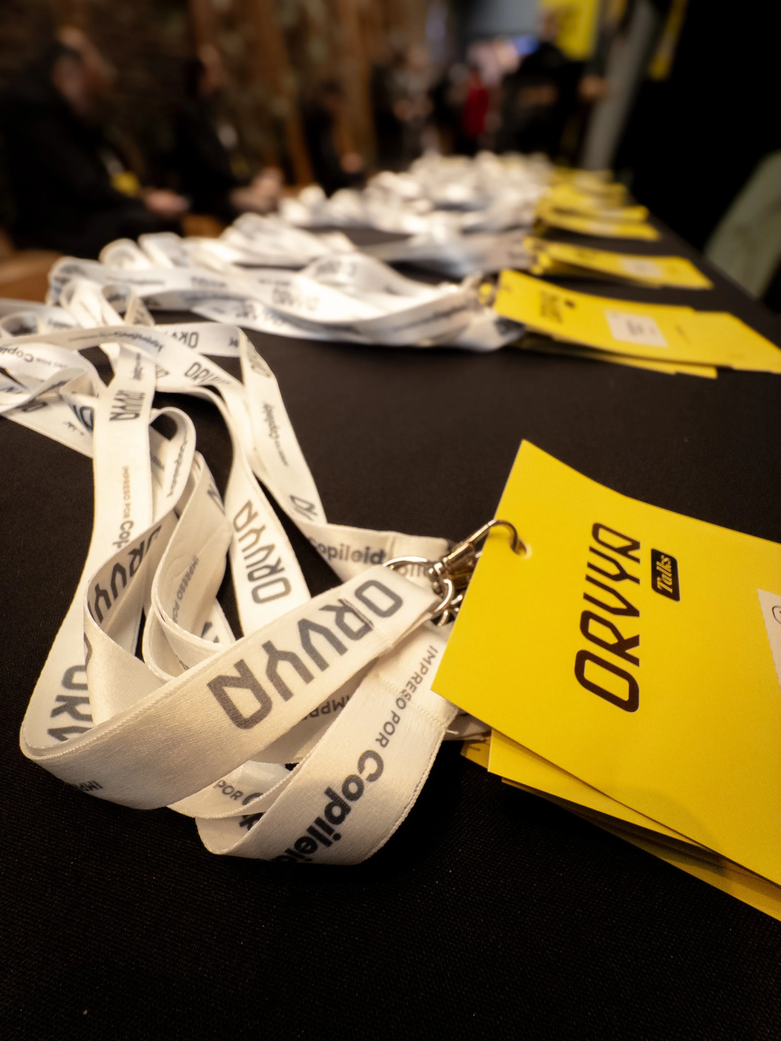 Rapidez y organización en la entrega de pases o acreditaciones en un evento con varias personas y papel en la mesa.