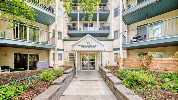 Apartment building entrance with balconies, greenery, and sign reading 'Dover Point S.E. Point of View'.