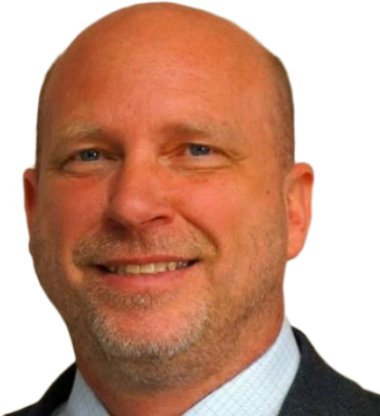 Close-up photo of a smiling middle-aged man with a shaved head, light beard, wearing a suit and tie.