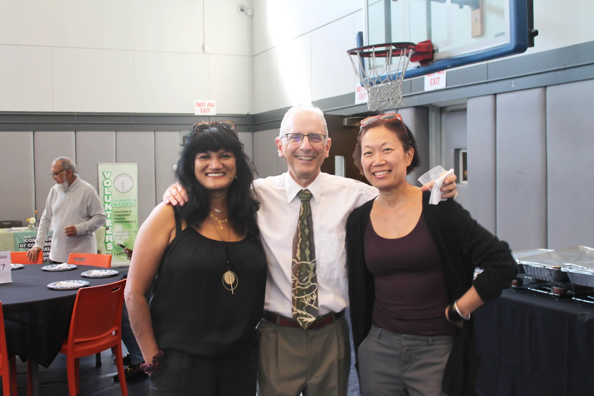 Three volunteer pose at the event for a photo.
