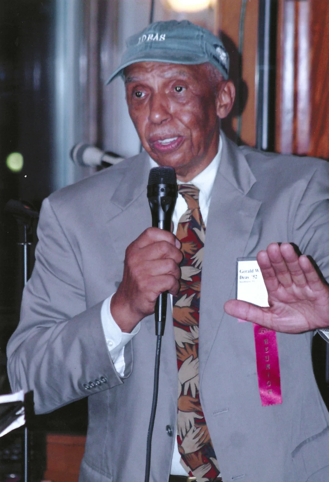 A doctor addressing attendees via microphone at a celebration.