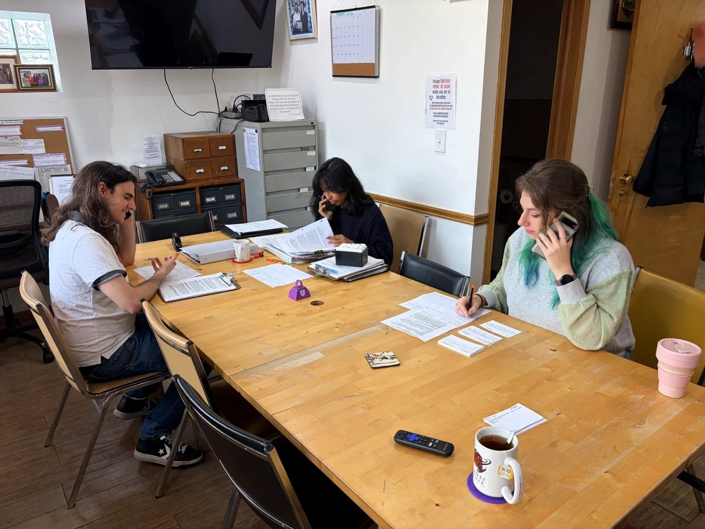 Three CCMP volunteers make phone calls.