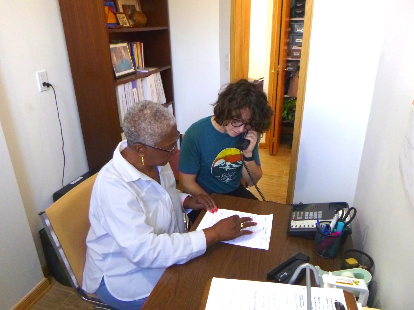 Two volunteers work off a list and make phone calls.