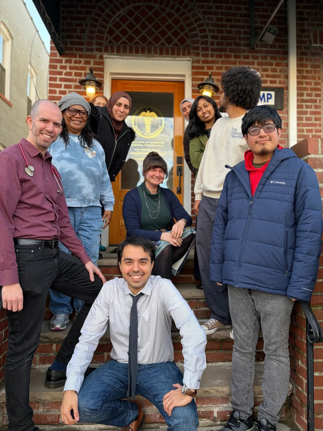 A group of volunteers and a doctor sitting in front of CCMP's office in Canarsie Brooklyn.