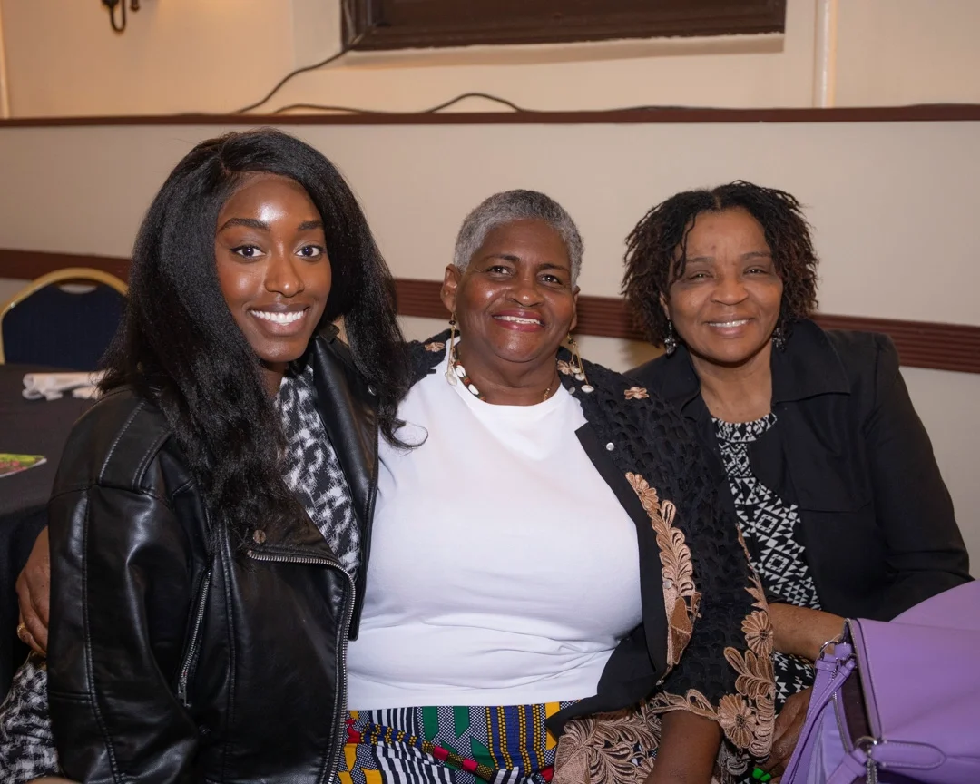 Three volunteer smile at CCMP's event. 