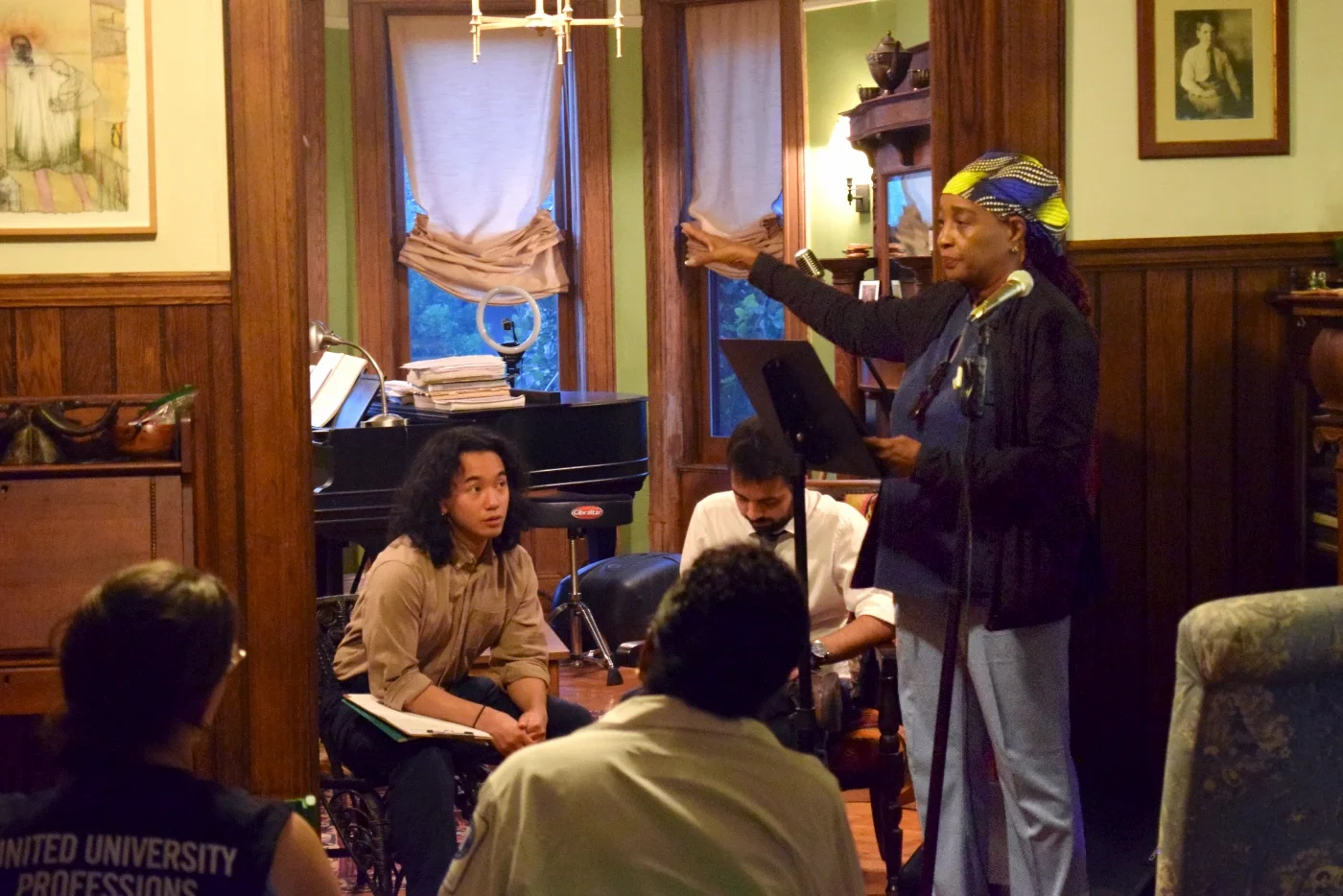 A CCMP house meeting where a presenter is speaking to the audience about CCMP's work.