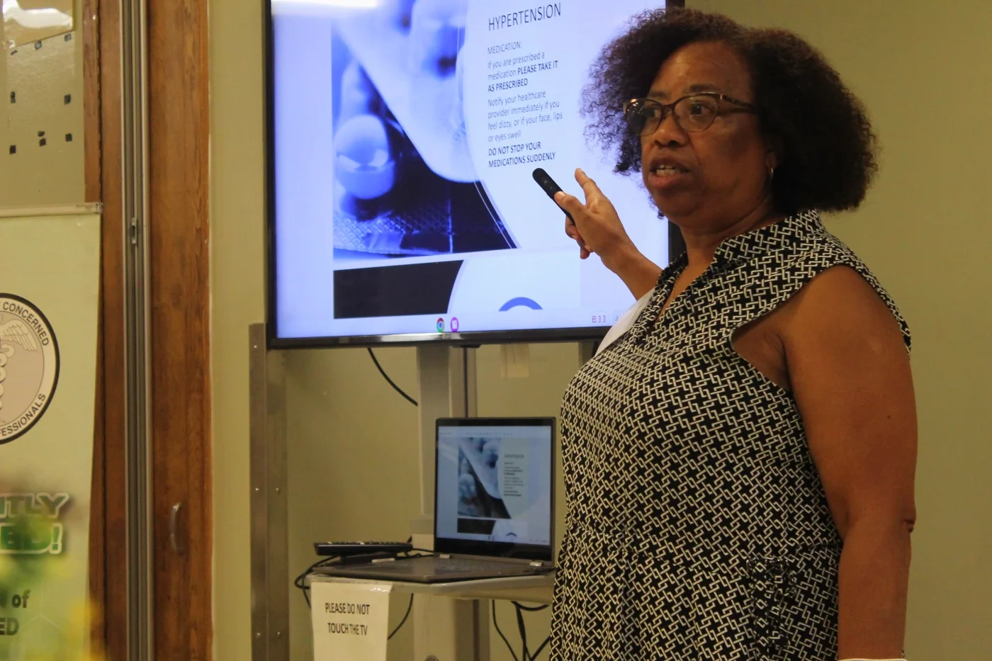 A volunteer CCMP medical professional points to a power point slide show 