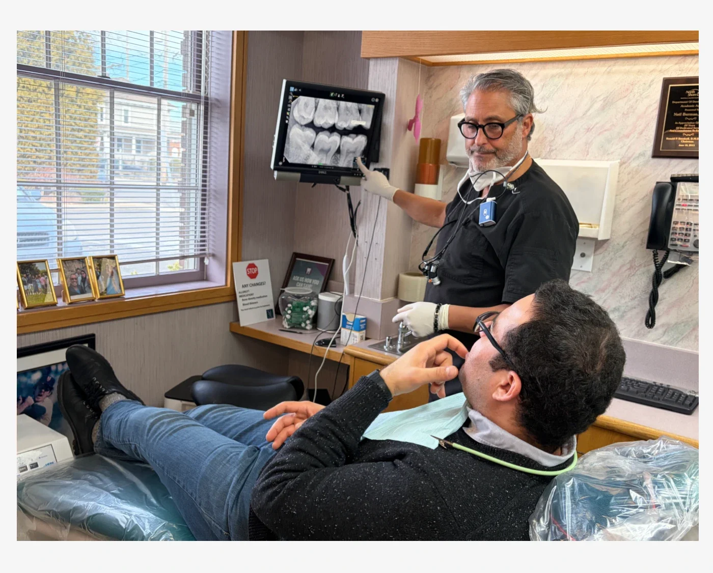 A volunteer dentist review x-rays with someone before a dental appointment. 