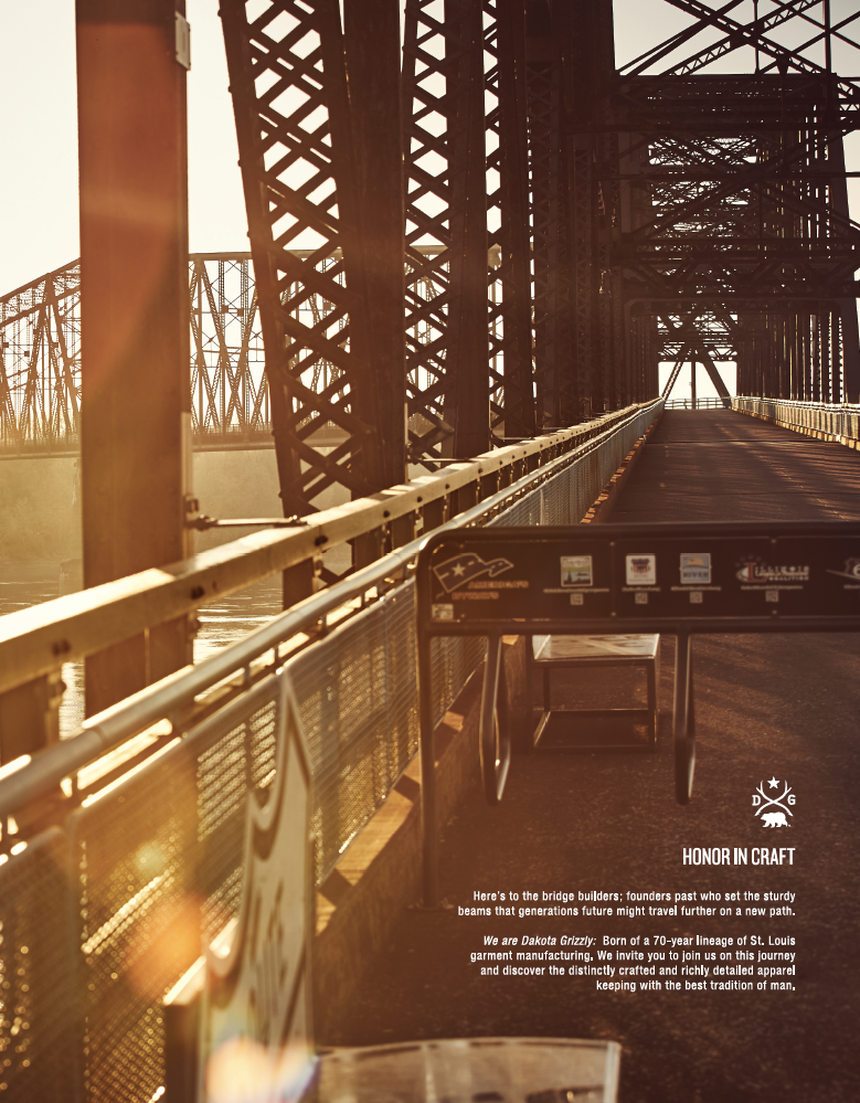 Photograph of a bridge under construction during sunset, showing steel framework and walkway, with some signage and the text "HONOR IN CRAFT" and a brief description about bridge builders and Dakota Grizzly brand.