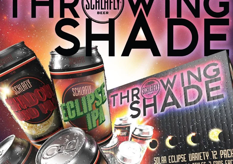 Packaging and cans of Schlafly Solar Eclipse Variety 12-pack beer, featuring a cosmic-themed background with moons and a solar eclipse, and a sign that says 'Throwing Shade'.