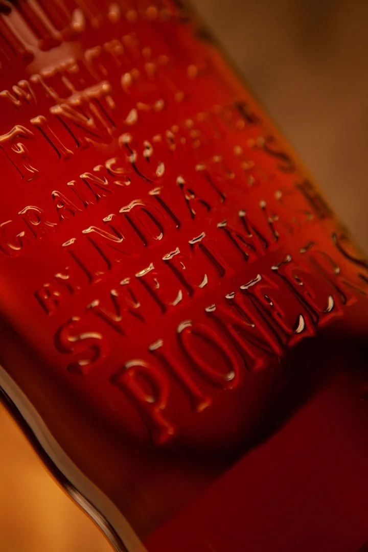 Bespoke Bottle Embossing featuring the brand statement Distilled with the finest grains and water from Indiana's Sweet Mash Pioneers"