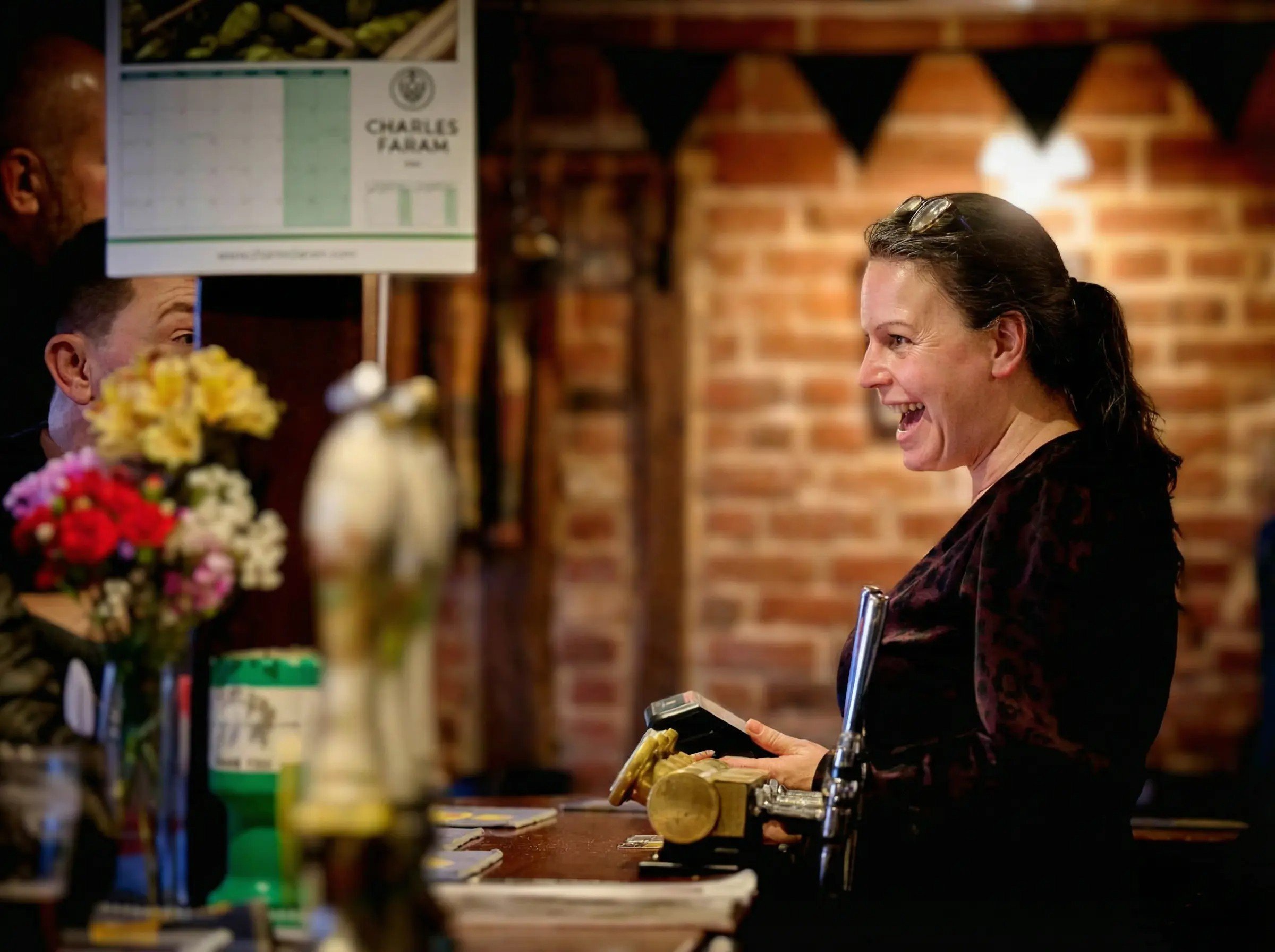 A photo of a smiling staff member behind the bar