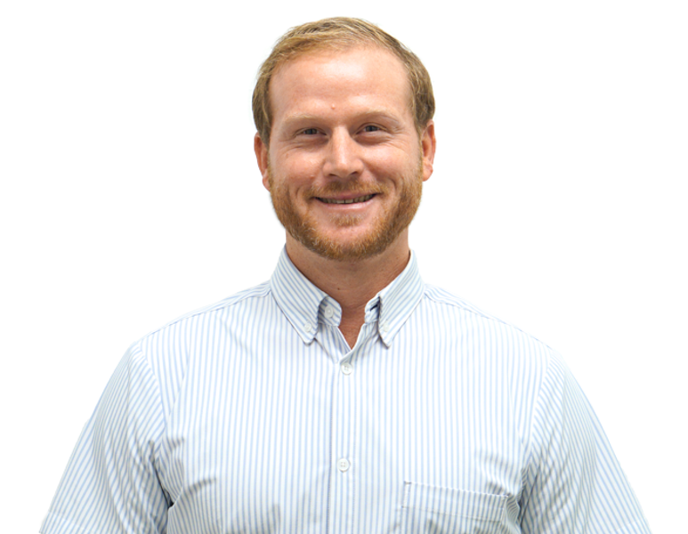 A man with light brown hair and a beard wearing a white and blue striped dress shirt smiling at the camera against a white background.