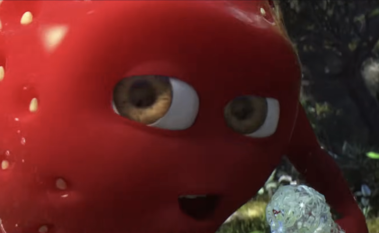 A close-up of a red strawberry with three eyeballs attached.