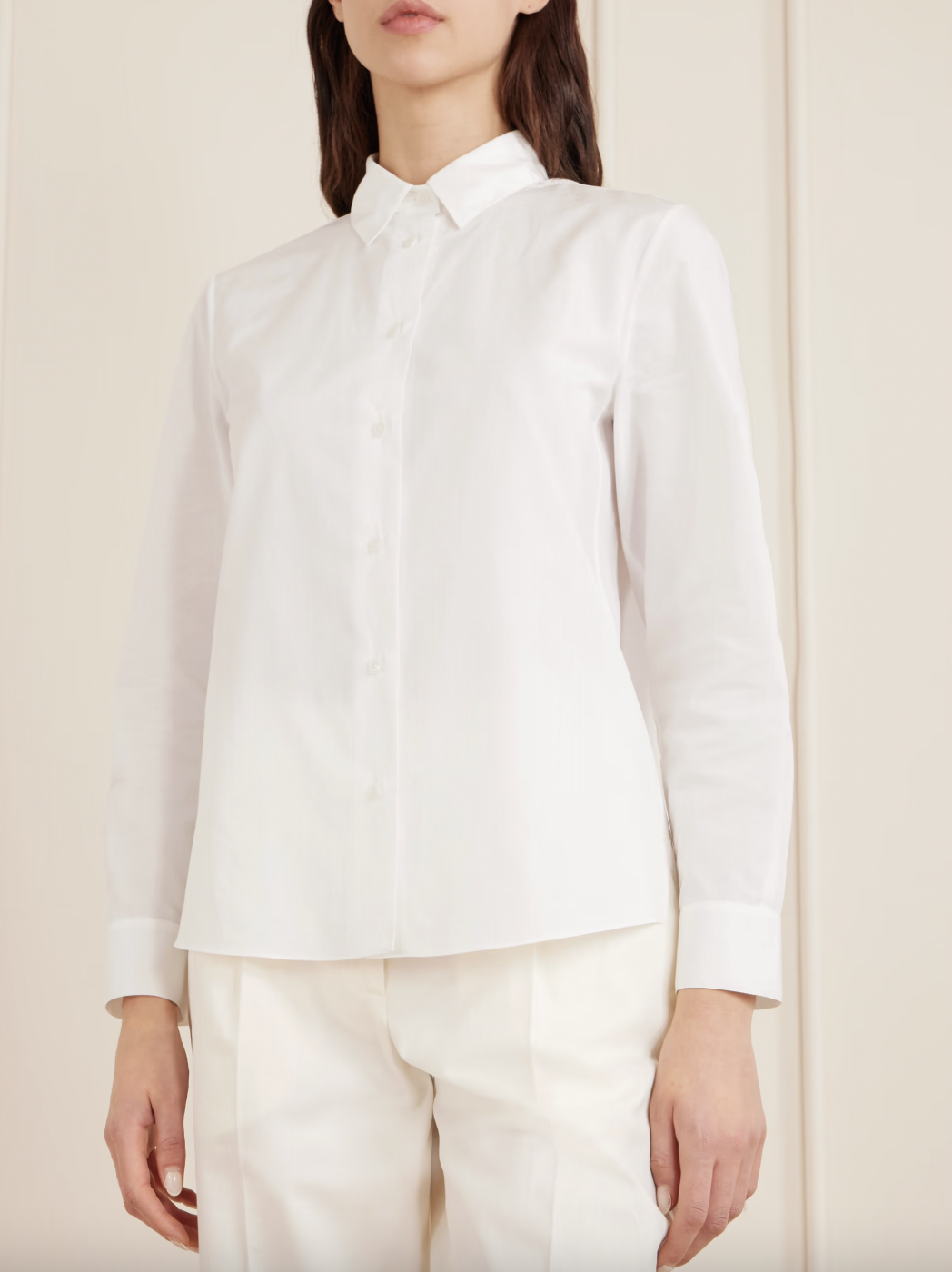 A model wears a The Row Sadie cotton-poplin shirt with a pair of cream trousers