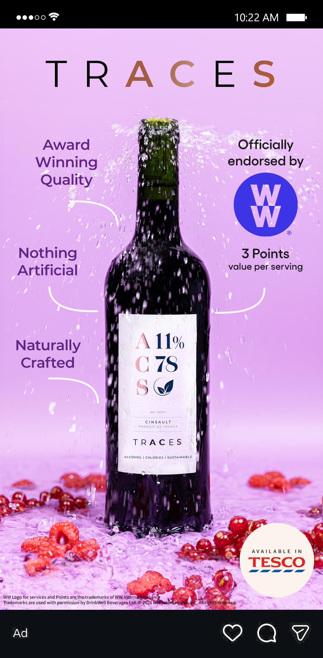 A wine bottle submerged in pink liquid with red berries, water splashing, and promotional text for the wine, including awards, endorsements, and features such as natural and artificial ingredients, with the Tesco logo.