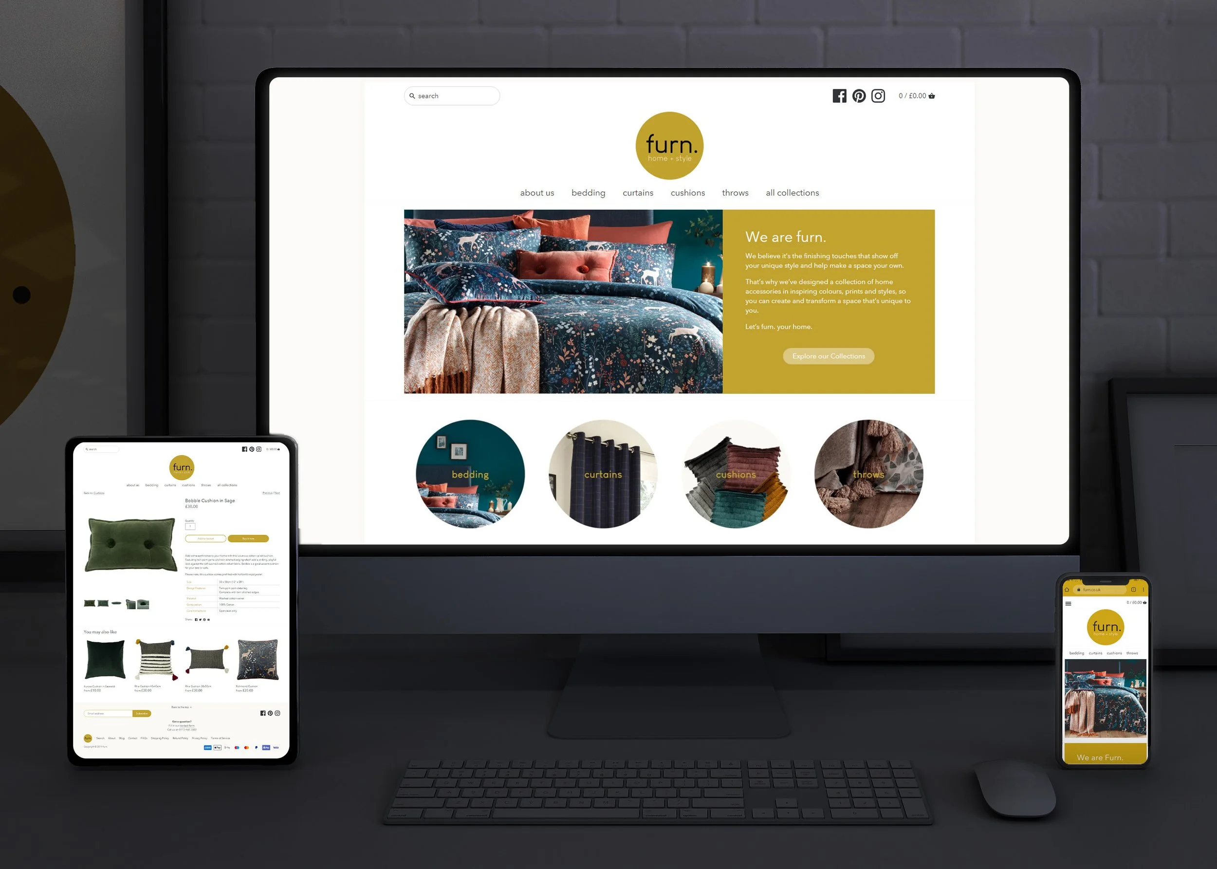 Multiple electronic devices displaying a website for 'furn.' home and style, featuring images of home decor items such as bedding, cushions, curtains, and throws, with a dark background and a visible keyboard.