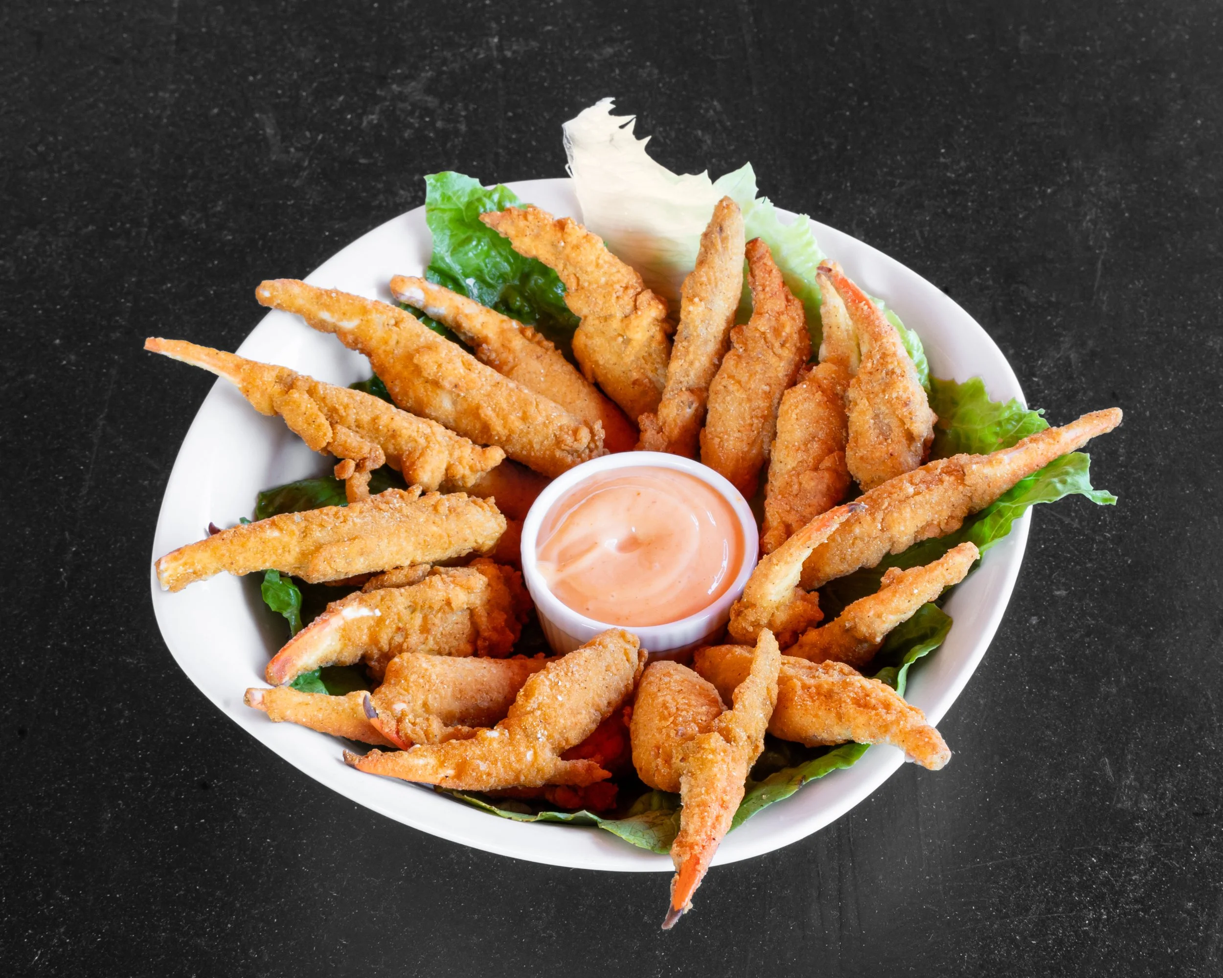 Bowl of fried fish fillets with lettuce and dipping sauce