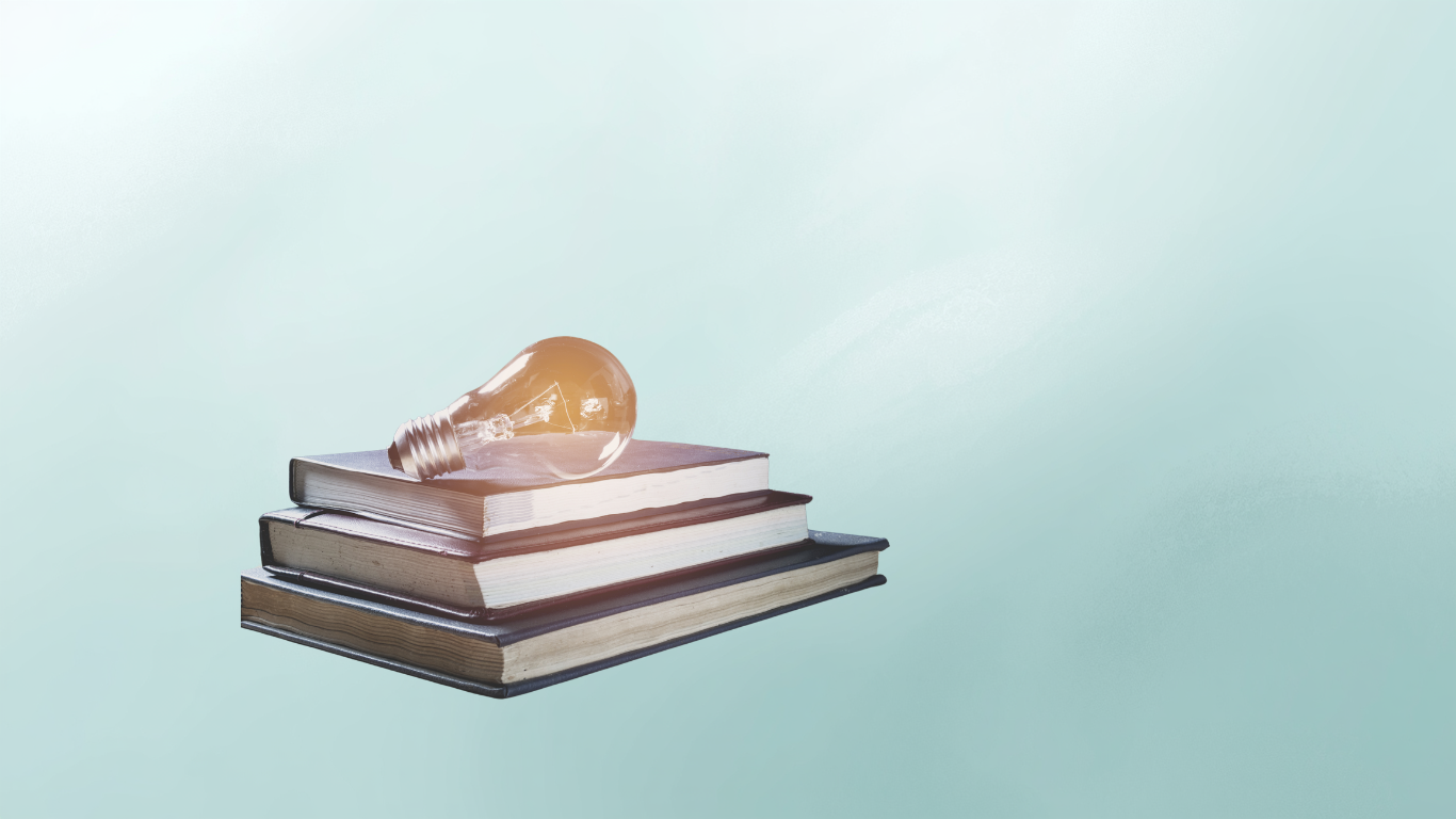 A stack of hardcover books with a lightbulb resting on top against a gradient light blue background.