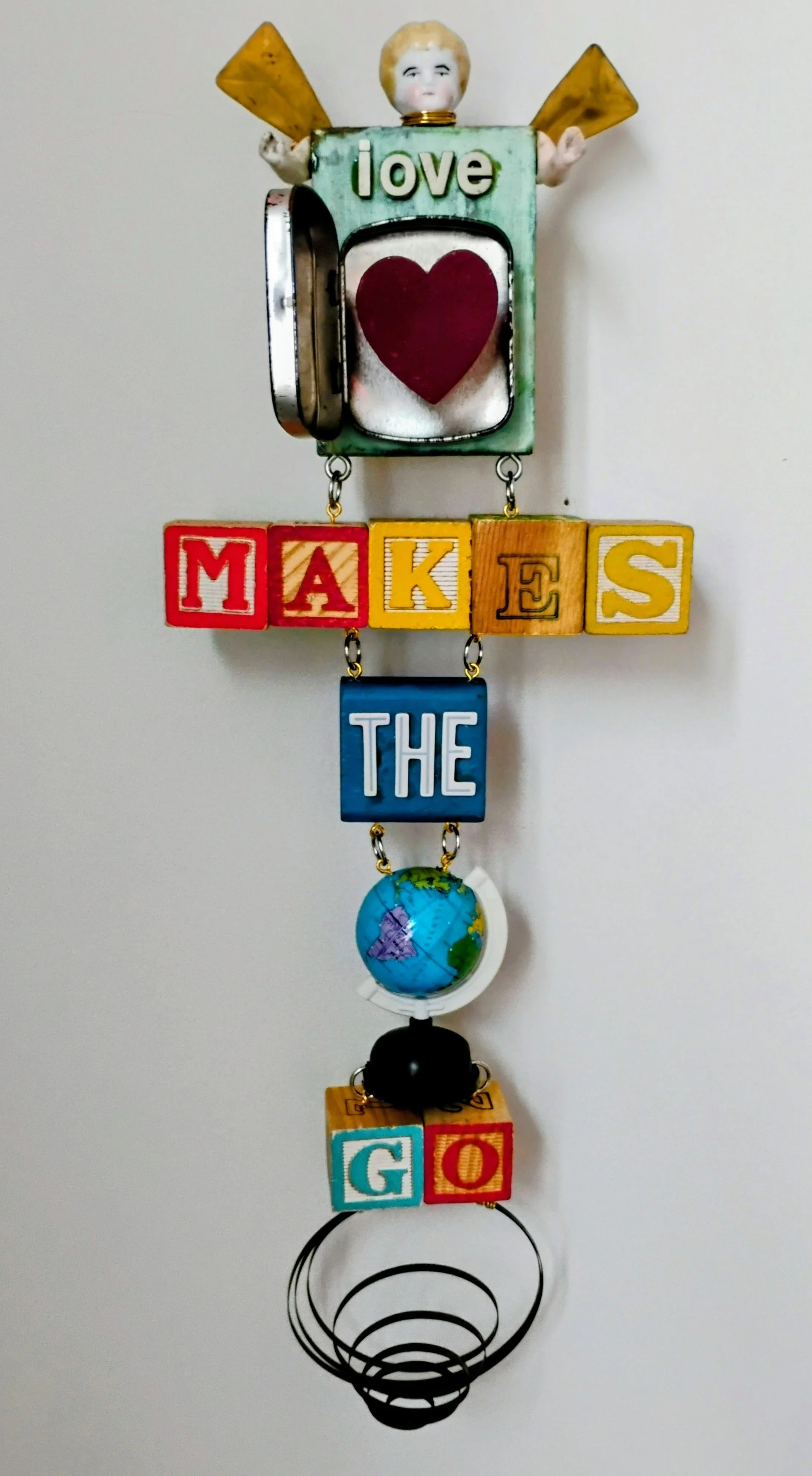 Love Makes the World Go 'Round. Vintage toy globe and the and the inner spring from a wind up clock. $175.00