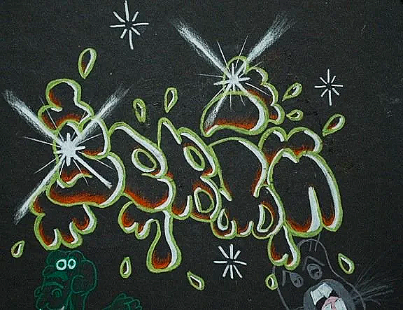Colorful graffiti of the word "Hombre" on a black wall, with cartoon dog and cat characters underneath.